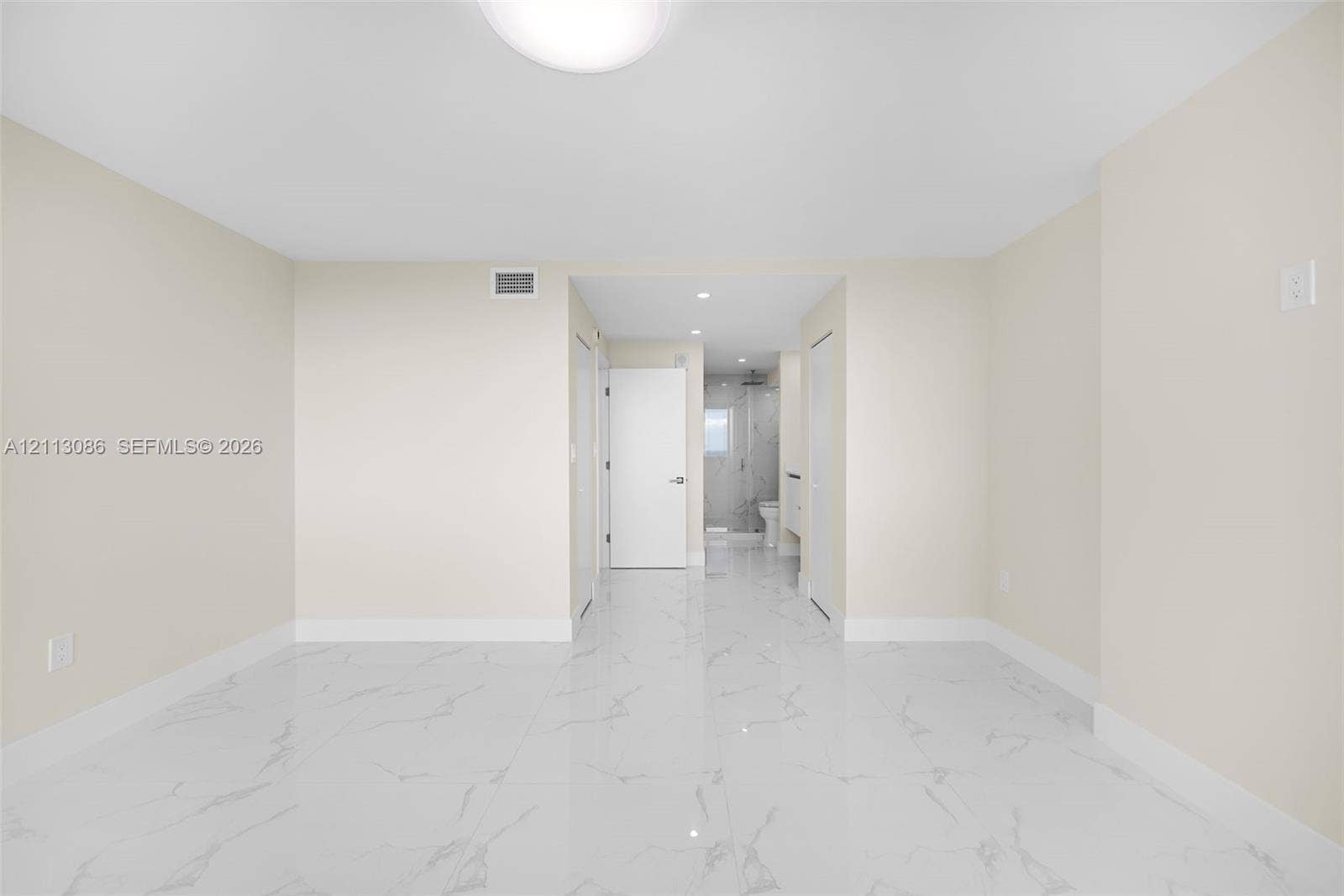 7135 Collins Avenue, #1632, Miami Beach, FL 33141 Bright interior space featuring polished white tile flooring with grey veining, crisp neutral walls, and recessed lighting