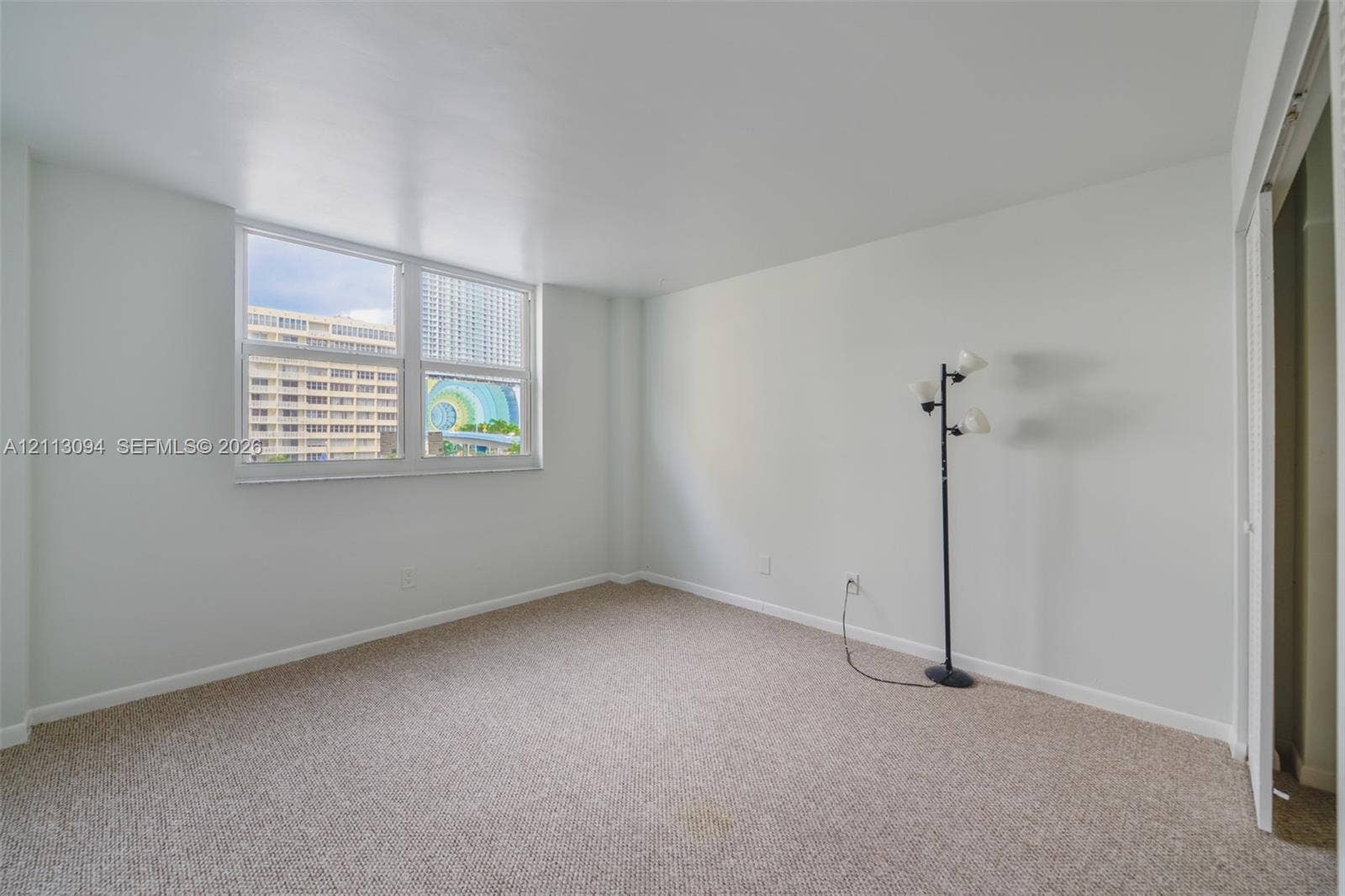 Neutral-toned interior space featuring wall-to-wall carpeting and an expansive multi-pane window