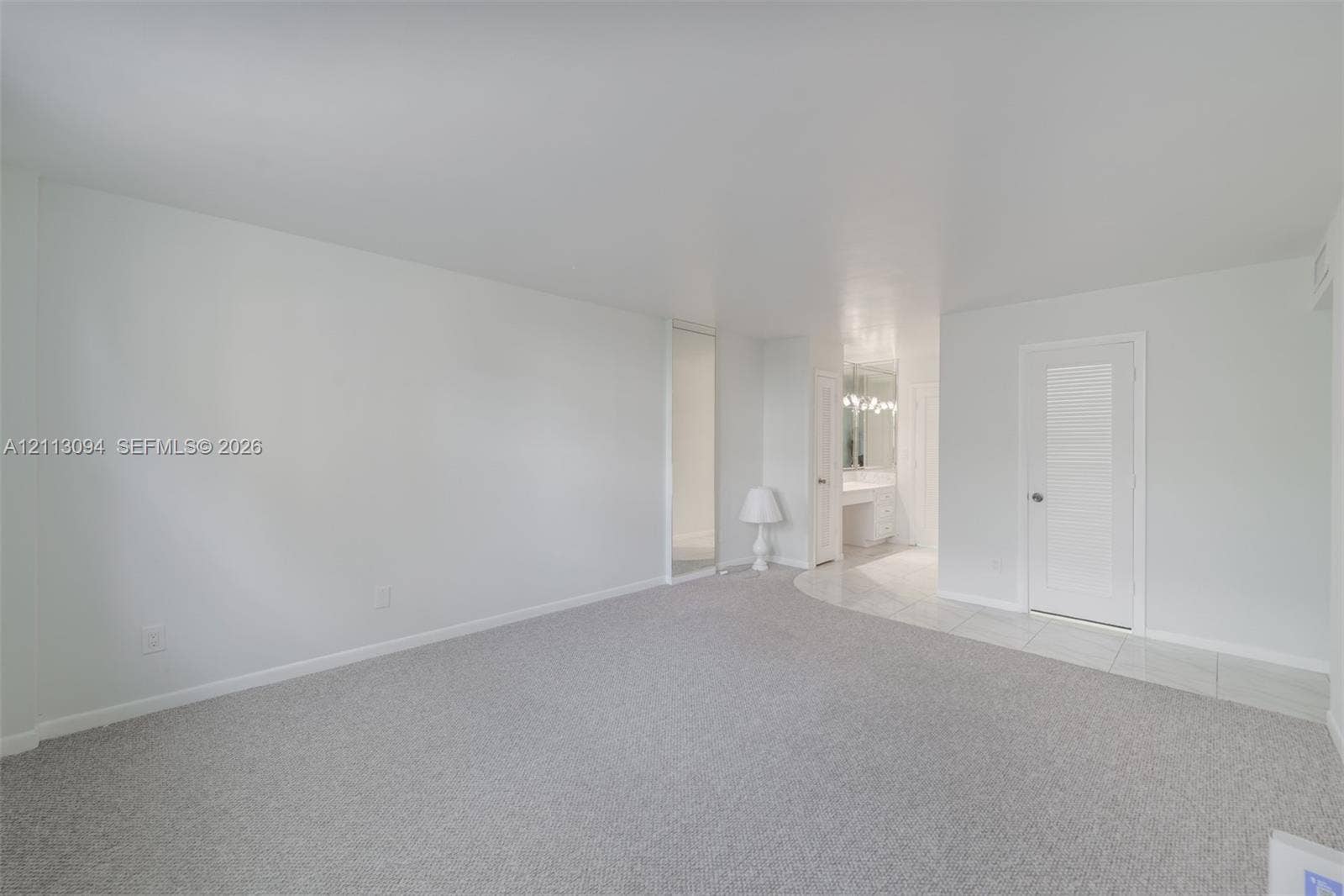 Neutral-toned wall-to-wall carpeting, white paneled doors, and smooth finished walls