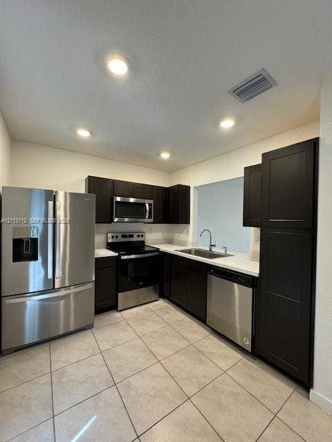 557 NE 5th Terrace, Florida City, Florida City, FL 33034 Kitchen featuring dark-finish cabinetry, solid-surface countertops, stainless steel appliances, and tile flooring