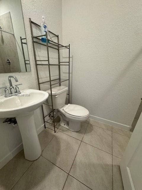 557 NE 5th Terrace, Florida City, Florida City, FL 33034 Pedestal sink with a dual-handle chrome faucet, large rectangular mirror, and neutral-toned floor tiling