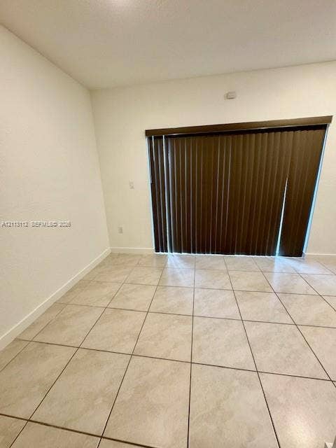 557 NE 5th Terrace, Florida City, Florida City, FL 33034 Neutral-toned tile flooring and full-height sliding glass doors featuring vertical blinds