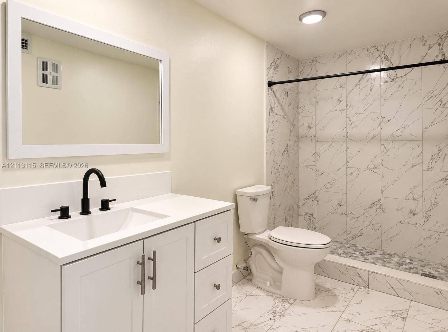 8705 NW 38th Drive, #4A, Coral Springs, Coral Springs, FL 33065 White cabinetry vanity with solid surface countertop, undermount sink, matte black faucet, and full-wall mirror