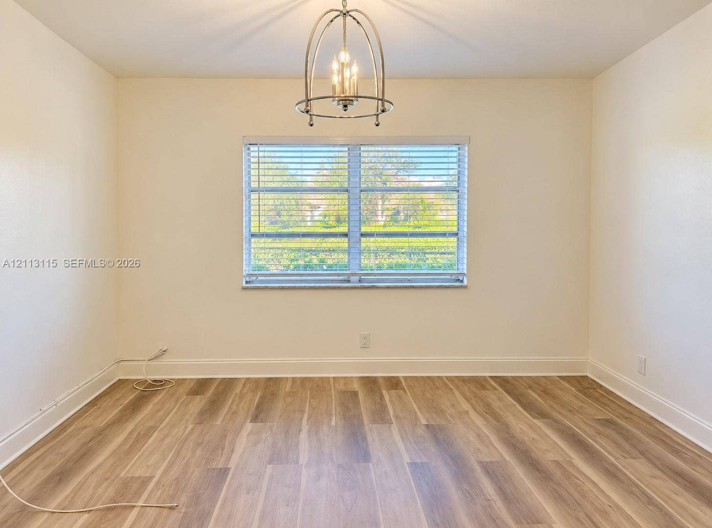 8705 NW 38th Drive, #4A, Coral Springs, Coral Springs, FL 33065 Wood-finish flooring, central metal cage chandelier, and window with horizontal blinds