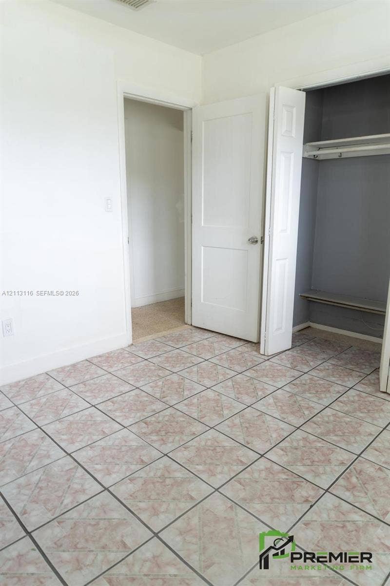 4341 NW 178th Drive, Miami Gardens, FL 33055 Tile flooring, white two-panel interior door, and built-in closet with overhead shelf and hanging rod