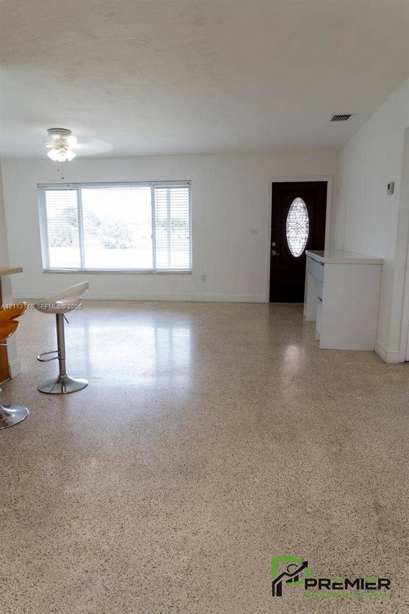 4341 NW 178th Drive, Miami Gardens, FL 33055 Terrazzo flooring, large multi-pane windows, dark-stained entry door with decorative glass insert, and built-in white cabinetry