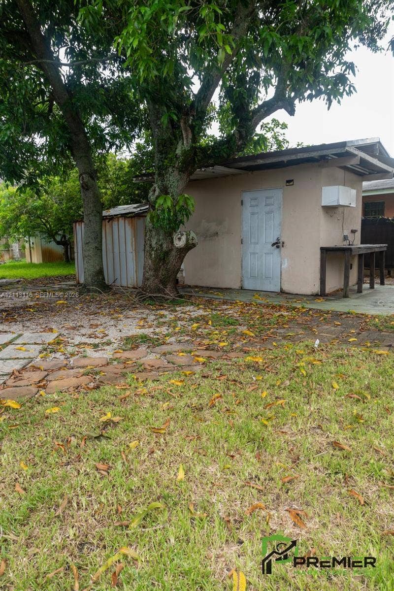 4341 NW 178th Drive, Miami Gardens, FL 33055 Detached structure featuring a masonry exterior, corrugated metal siding, and a paved stone pathway
