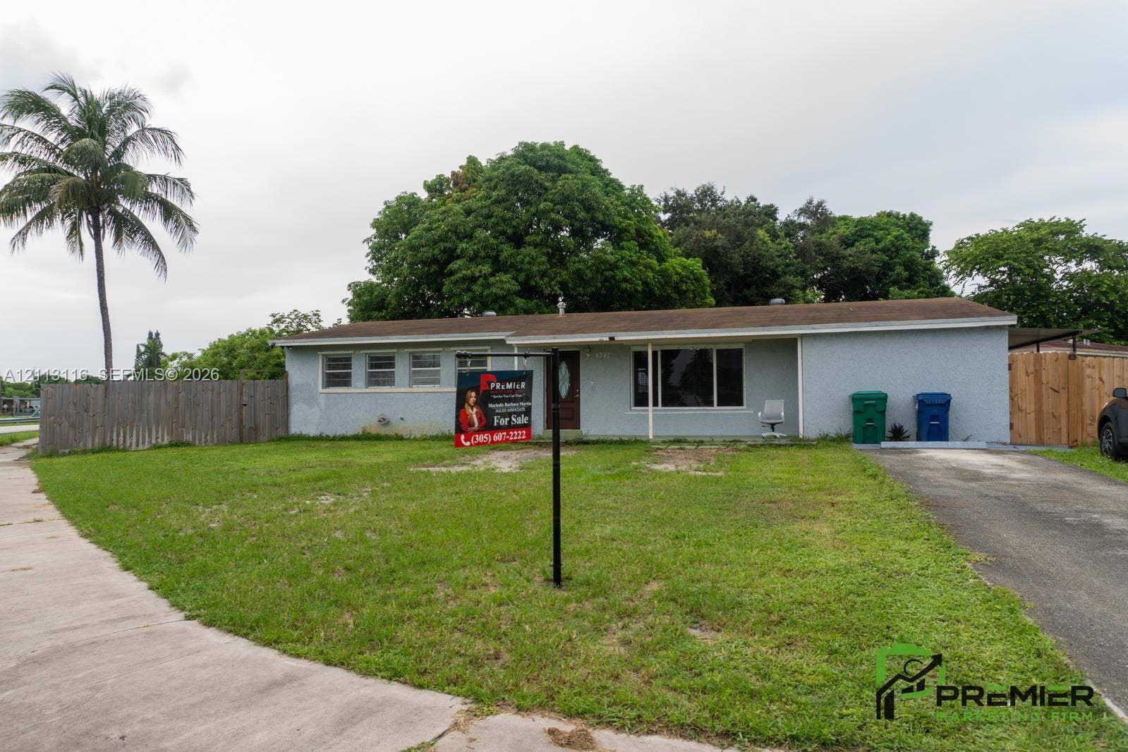 4341 NW 178th Drive, Miami Gardens, FL 33055 Single-story residence with a stucco exterior, a horizontal-plank wood fence, an asphalt driveway, and mature landscaping