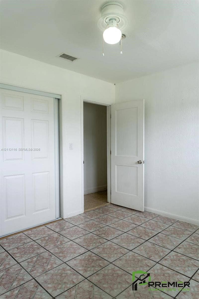 4341 NW 178th Drive, Miami Gardens, FL 33055 Tiled flooring, dual-panel sliding closet doors, and interior paneled door featuring metallic hardware