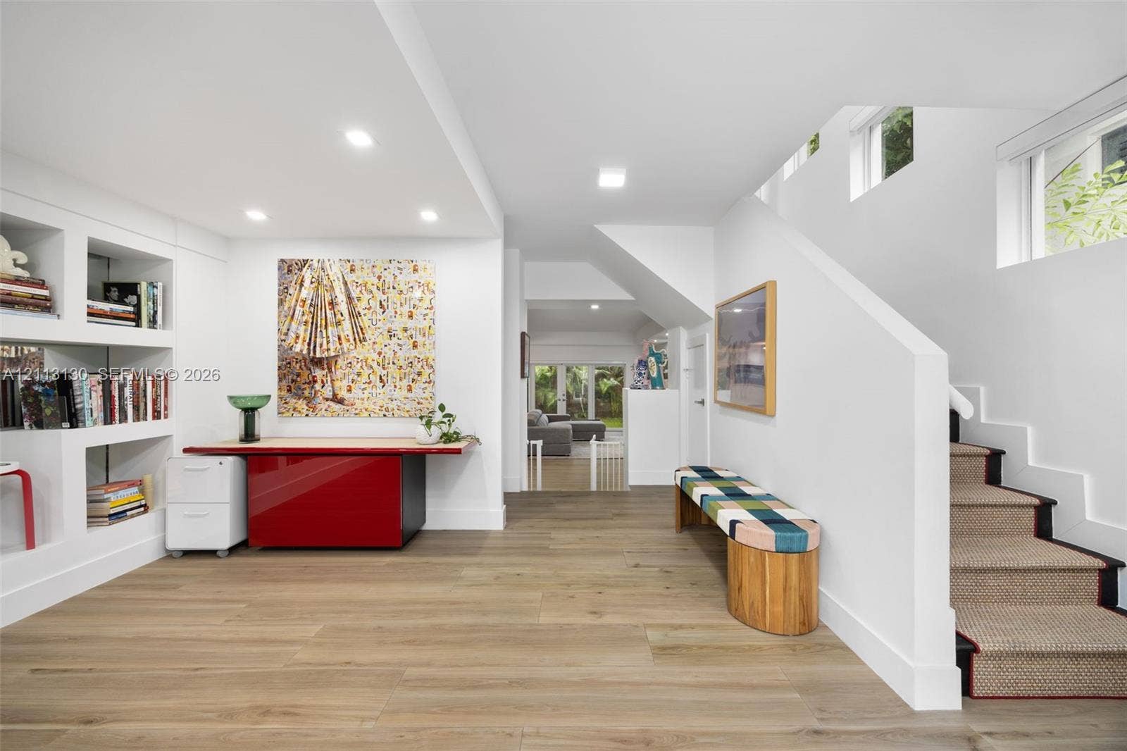 Interior space featuring wood-finish flooring, recessed lighting, built-in recessed shelving, and a staircase with textile runner