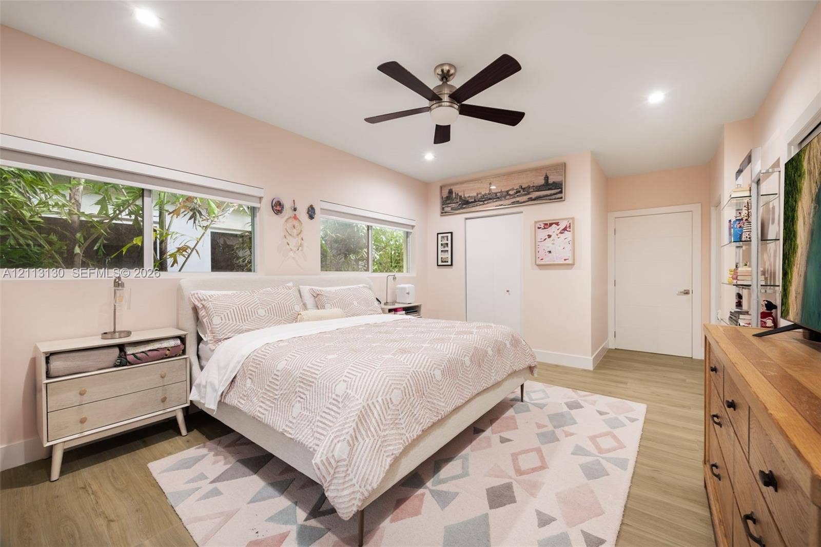 Wood-finish flooring, recessed lighting, ceiling fan with light kit, and large windows with horizontal blinds