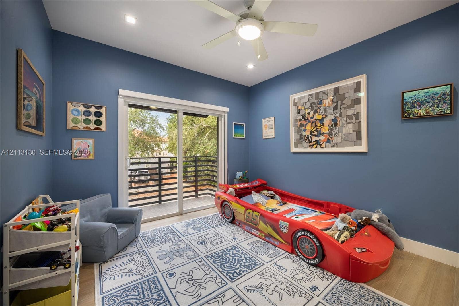 Interior room featuring wood-finish flooring, recessed lighting, a ceiling fan with integrated light fixture, and sliding glass doors with balcony access