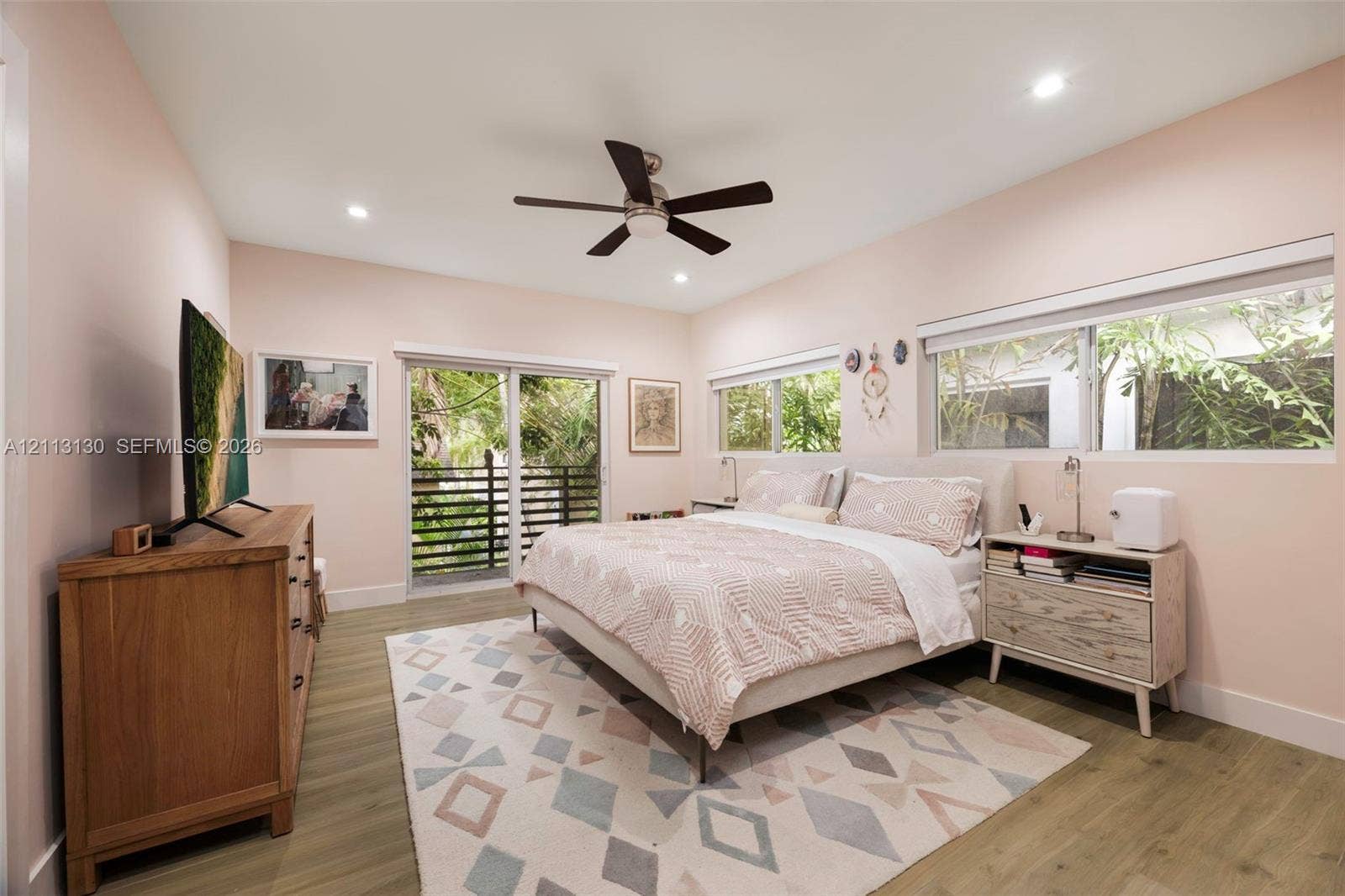 Wood-finish flooring, recessed lighting, ceiling fan, and sliding glass door with exterior balcony access