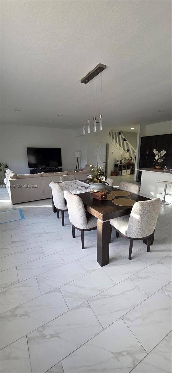 16474 Sea Turtle Place, Westlake, Westlake, FL 33470 Large-format tile flooring with a neutral veined finish, multi-light linear pendant fixture, and white cabinetry