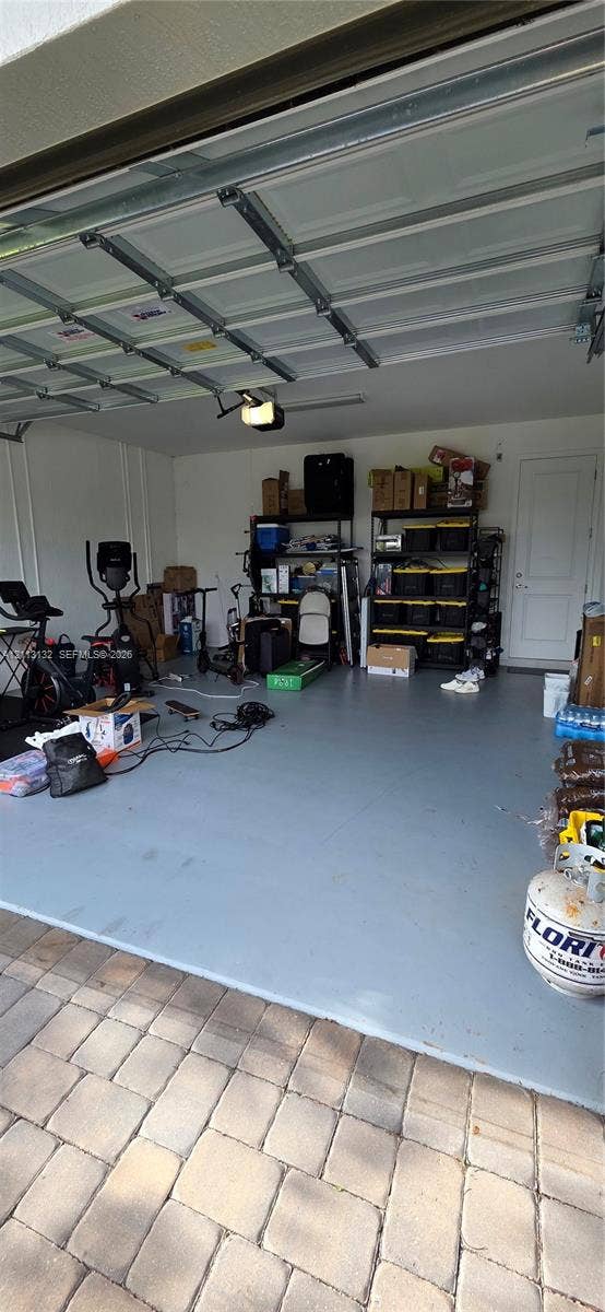 16474 Sea Turtle Place, Westlake, Westlake, FL 33470 Garage featuring painted concrete flooring, a sectional overhead door, and a dedicated service door