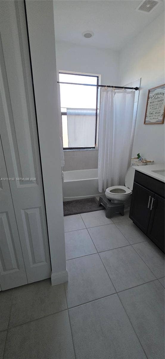 16474 Sea Turtle Place, Westlake, Westlake, FL 33470 Bathroom featuring large-format tile flooring, vanity with dark-finish cabinetry, countertop with integrated sink, and a combination bathtub and shower enclosure with a window