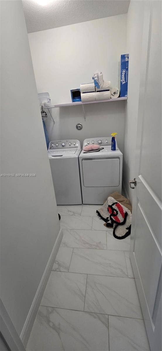 16474 Sea Turtle Place, Westlake, Westlake, FL 33470 Dedicated laundry alcove featuring large-format stone-patterned tile flooring and an integrated wall-mounted shelf