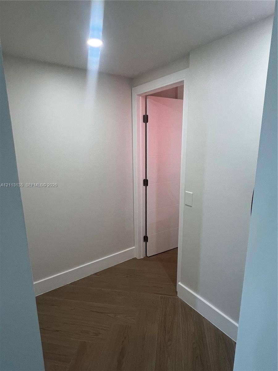 1600 S Ocean Drive, #3A, Hollywood, FL 33019 Herringbone-patterned wood-finish flooring, recessed ceiling lighting, and a solid-core interior door with matte black hardware