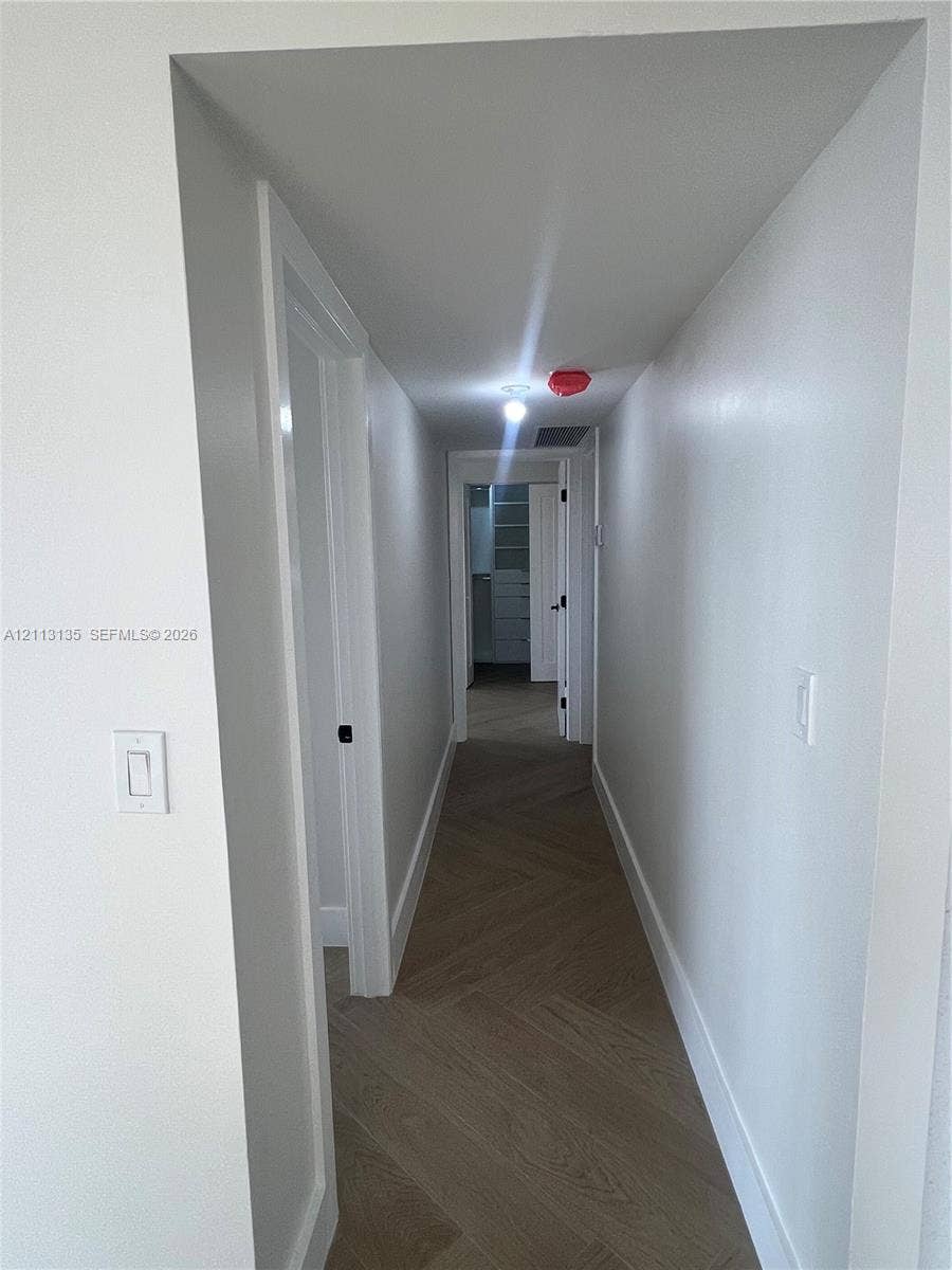 1600 S Ocean Drive, #3A, Hollywood, FL 33019 Hallway featuring herringbone-pattern wood-finish flooring, white walls, and interior passage doors