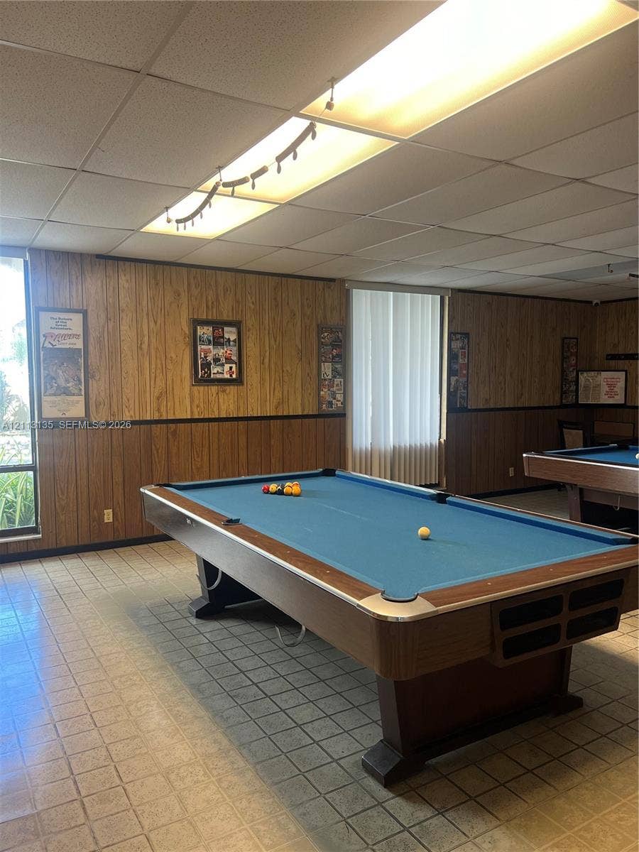 1600 S Ocean Drive, #3A, Hollywood, FL 33019 Wood-panelled wall treatments with chair rail molding, drop ceiling with integrated fluorescent lighting, and tile flooring