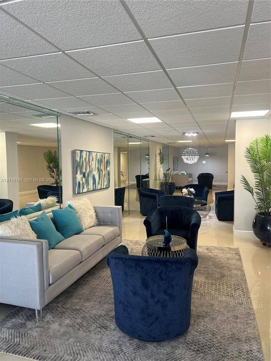1600 S Ocean Drive, #3A, Hollywood, FL 33019 Expansive interior space featuring high-gloss tile flooring, floor-to-ceiling mirror wall panels, and recessed drop-ceiling lighting