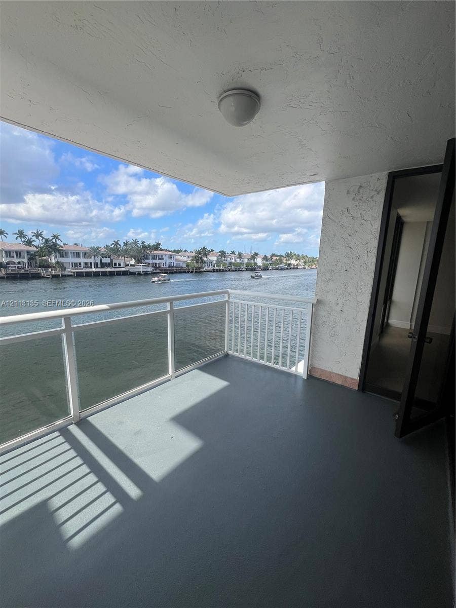 1600 S Ocean Drive, #3A, Hollywood, FL 33019 Covered balcony featuring water frontage, white metal railing, solid flooring, and textured wall finish