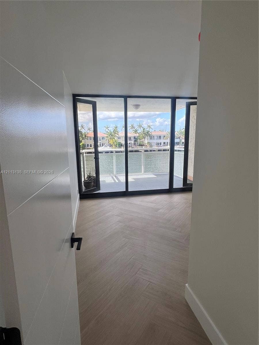 1600 S Ocean Drive, #3A, Hollywood, FL 33019 Herringbone-patterned wood-finish flooring, floor-to-ceiling glass panel doors, and a waterfront balcony with a railing