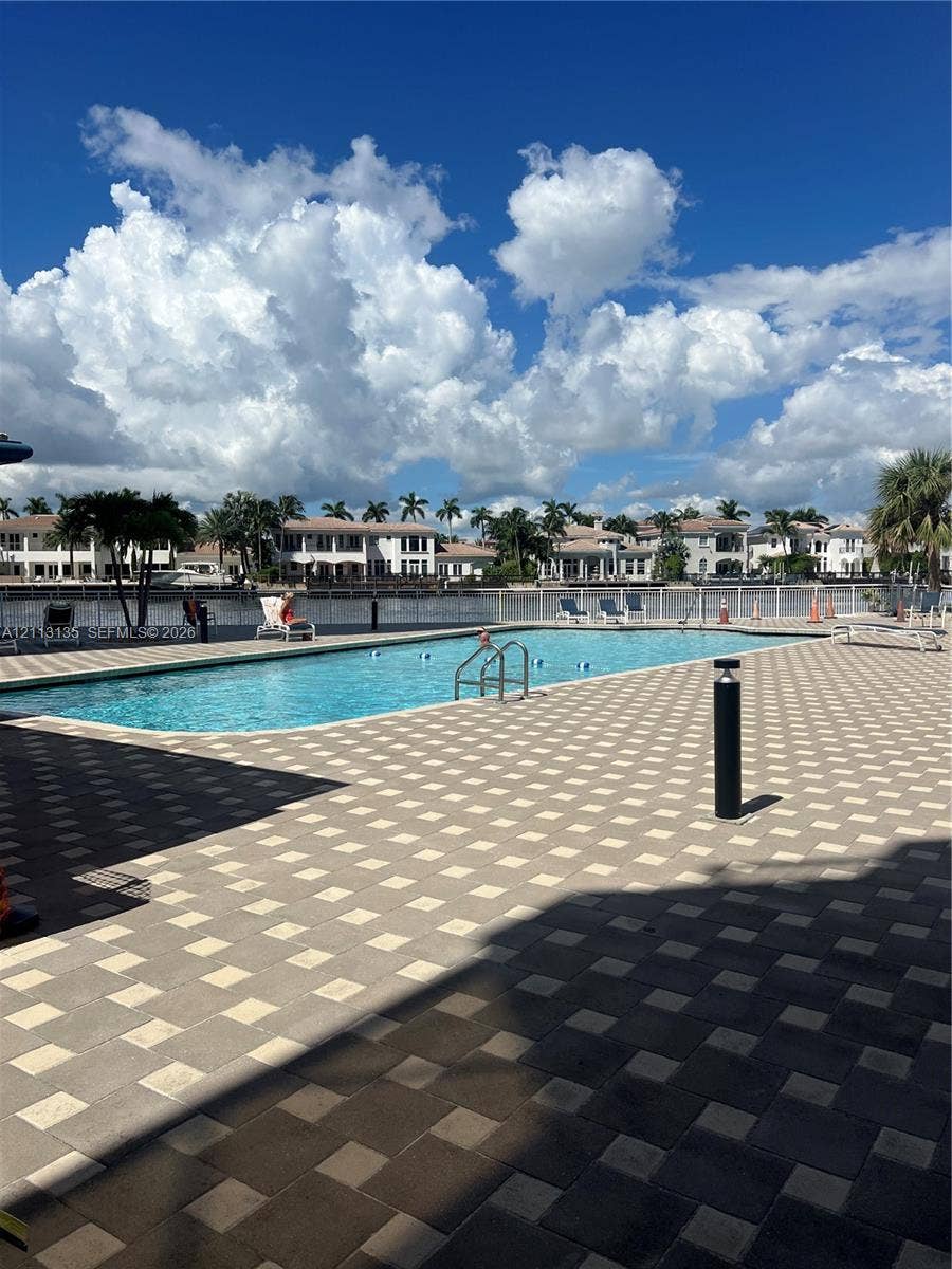 1600 S Ocean Drive, #3A, Hollywood, FL 33019 In-ground swimming pool featuring a geometric paver deck, metal safety fencing, and direct water frontage