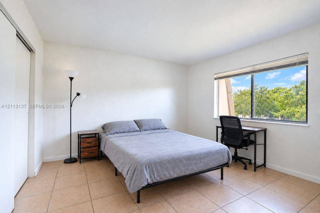 10884 Royal Palm Boulevard, #10884, Coral Springs, FL 33065 Neutral interior space featuring large-format ceramic tile flooring, a horizontal sliding window, and a sliding closet door