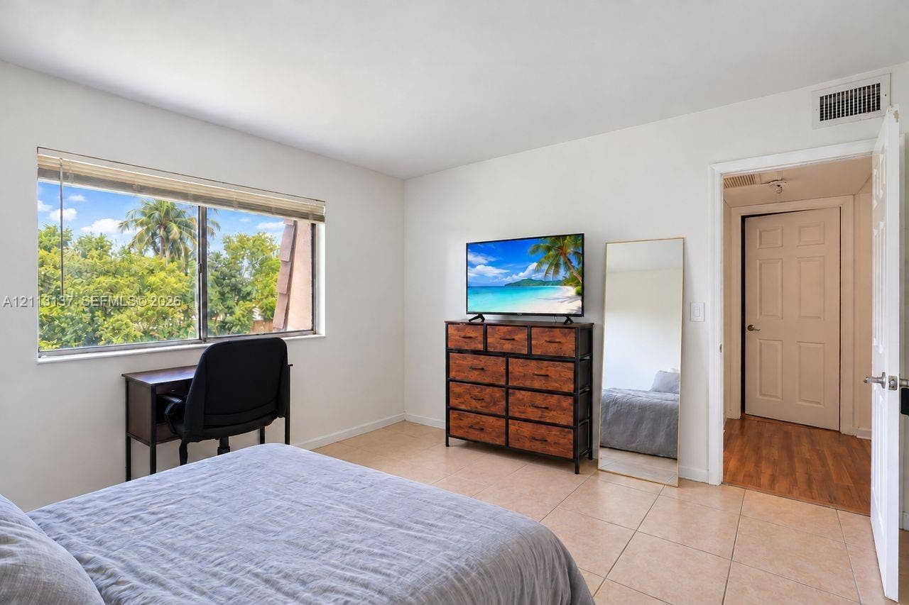 10884 Royal Palm Boulevard, #10884, Coral Springs, FL 33065 Room featuring neutral-toned tile flooring, large-format windows, and solid-core interior doors
