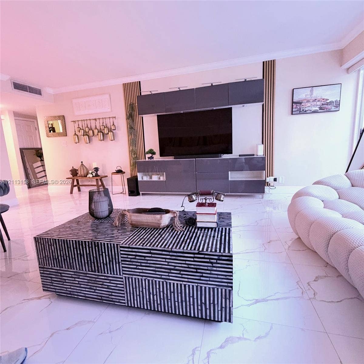 Large-format stone-look tile flooring with grey veining, built-in grey high-gloss cabinetry, and vertical wood-slat accent paneling