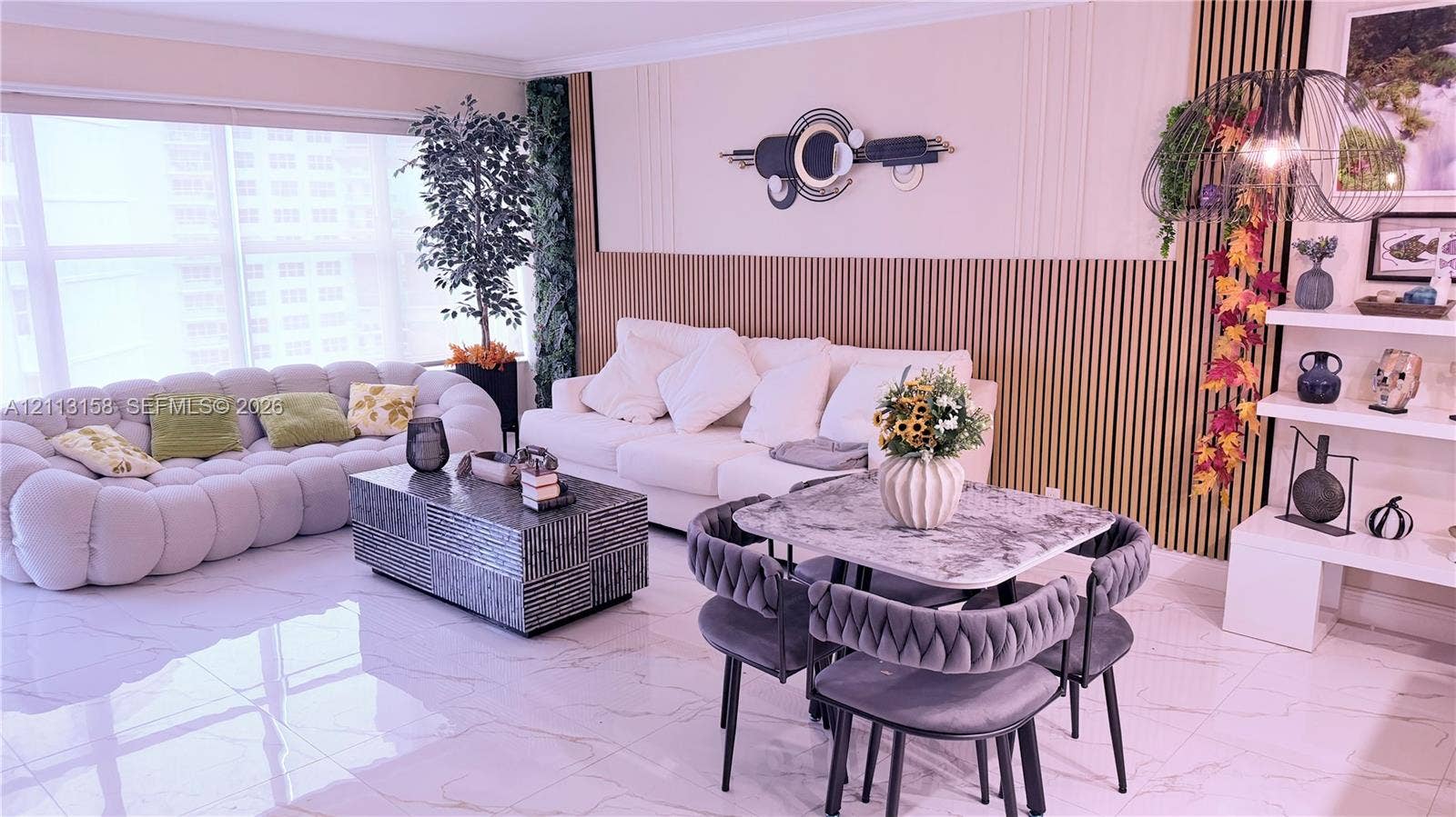 Living area featuring polished tile flooring, vertical wood-slat accent wall paneling, and built-in tiered shelving