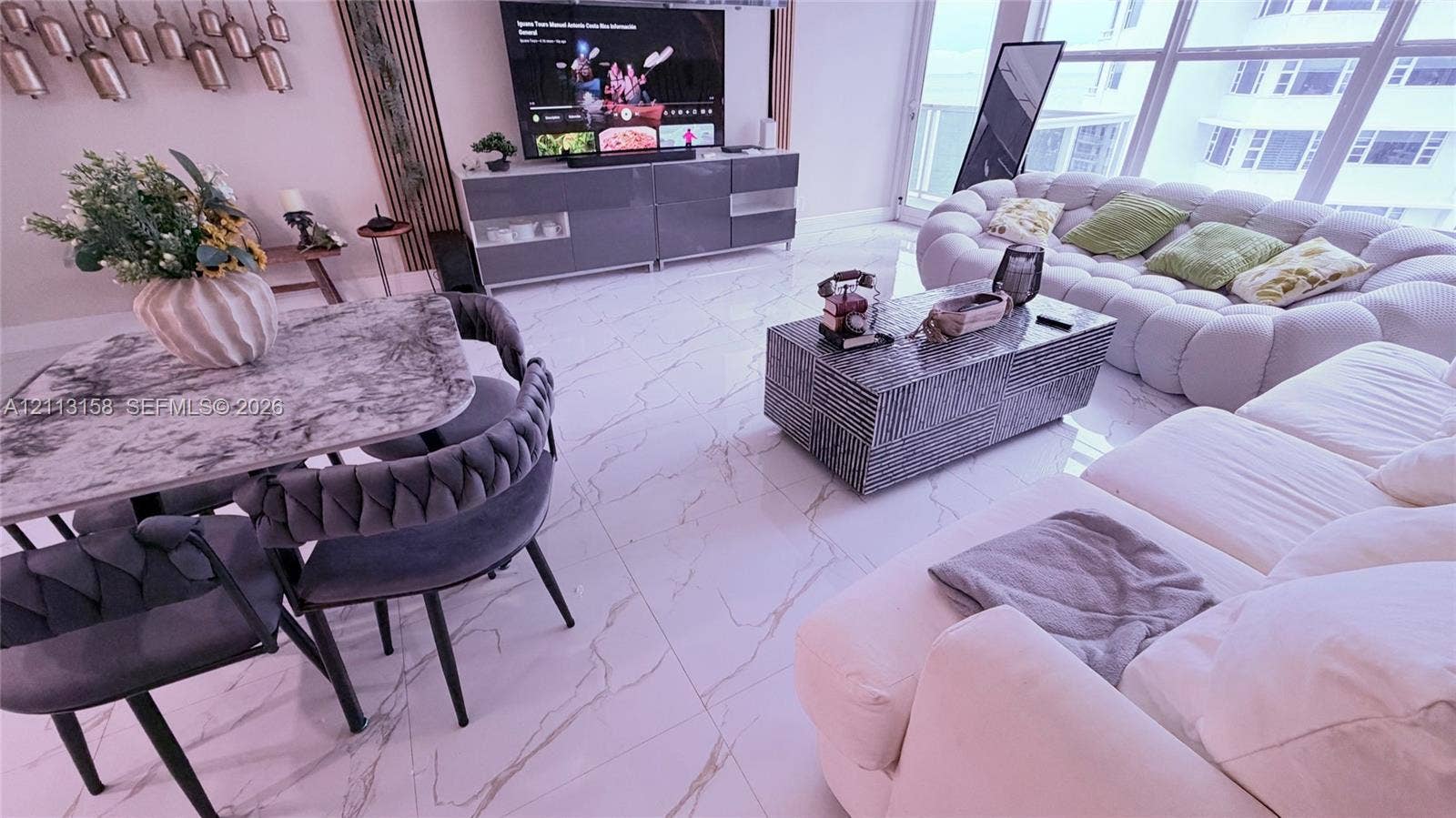 Large-format polished tile flooring, floor-to-ceiling windows, and linear wall-mounted accent paneling