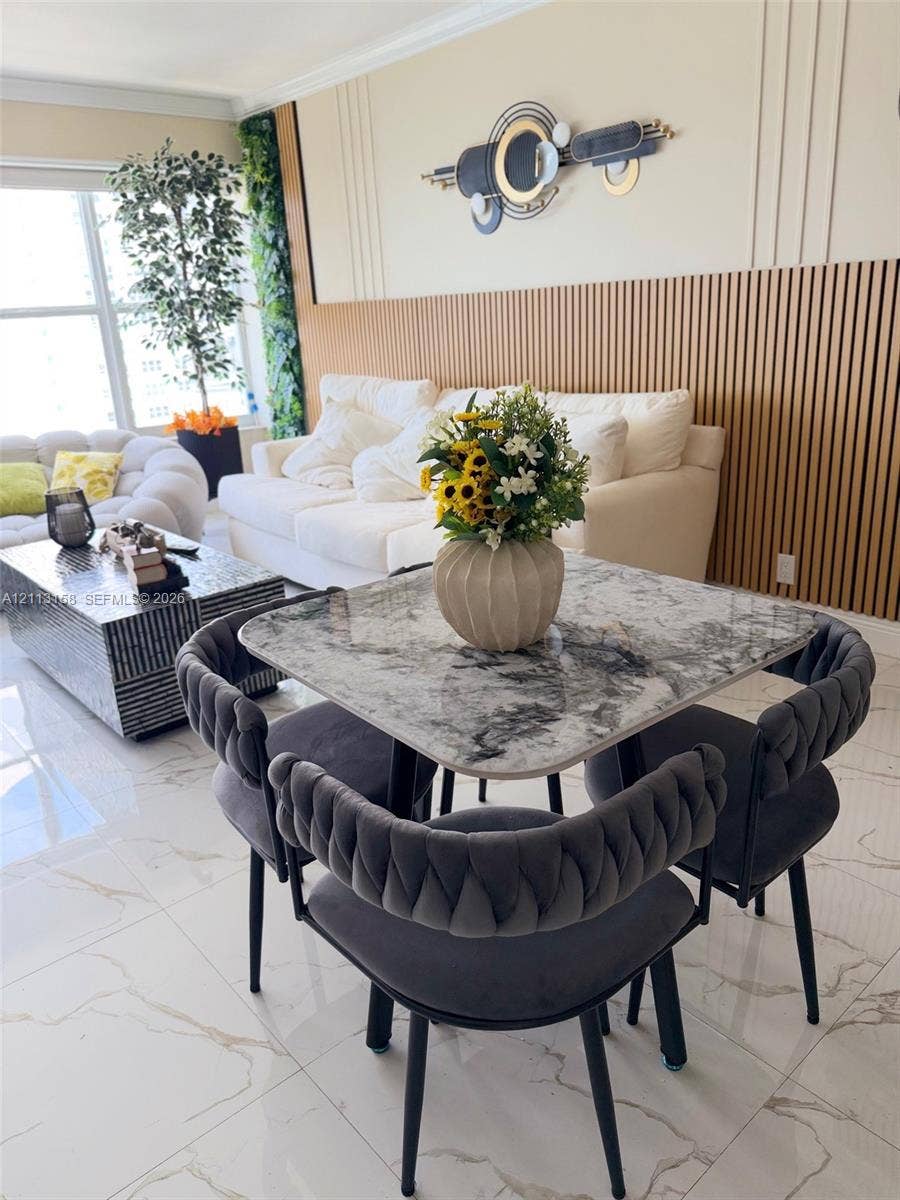 Interior space featuring large-format tile flooring, vertical wood slat wall paneling, and wall-mounted decorative trim