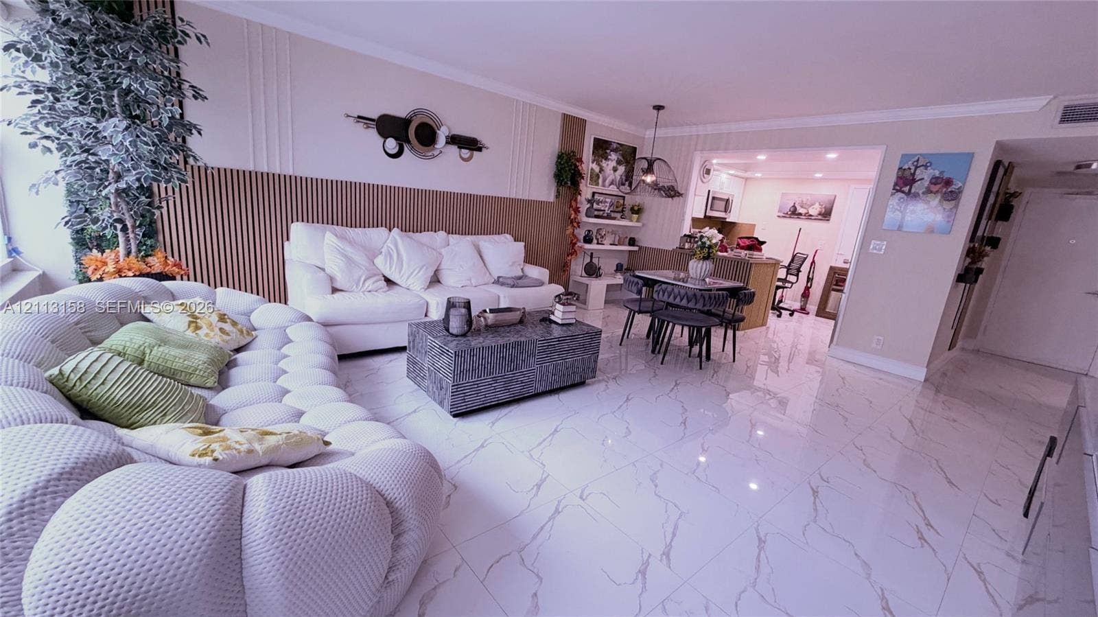 Living area featuring polished tile flooring with stone-patterned veining and floor-to-ceiling vertical wood-slat accent wall paneling
