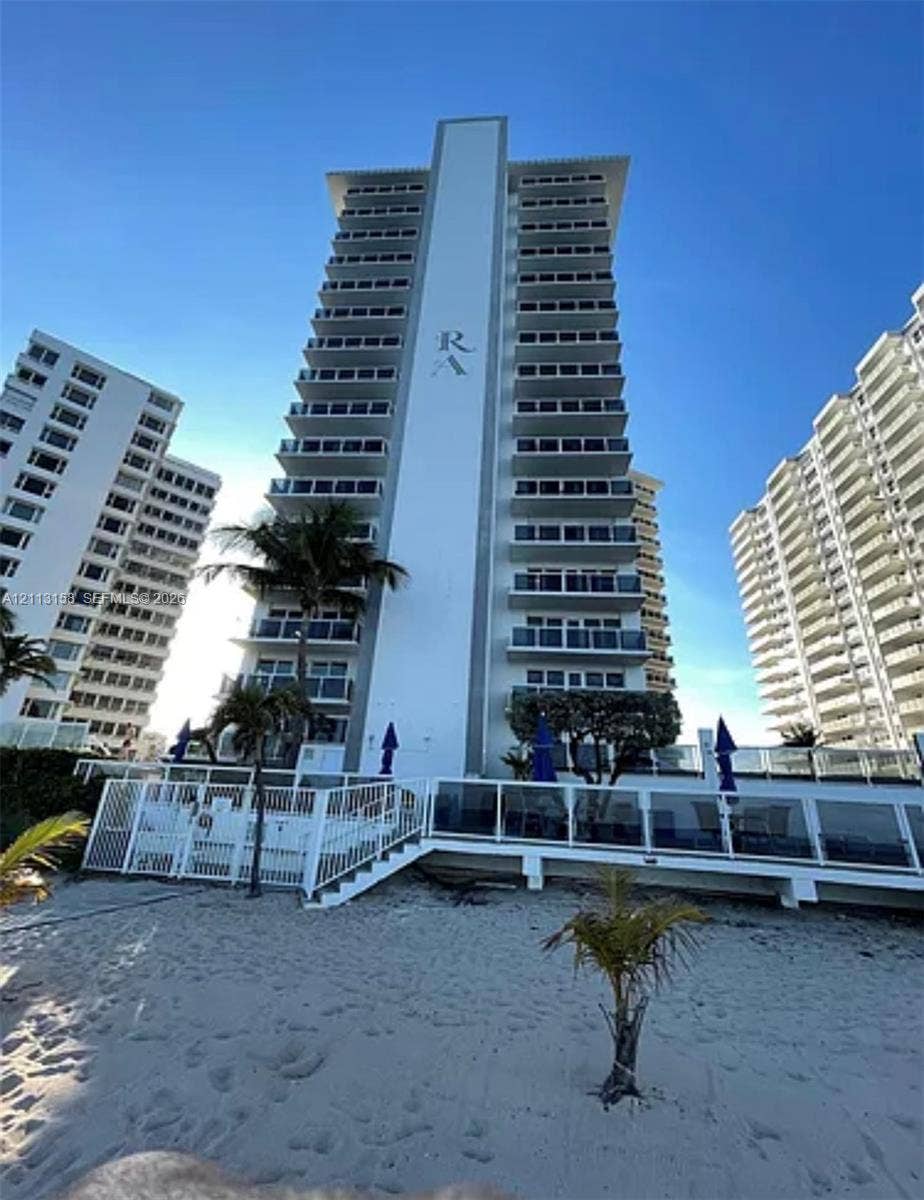 High-rise residential exterior featuring private balconies, floor-to-ceiling glass railings, direct sand access, and structural palm tree landscaping