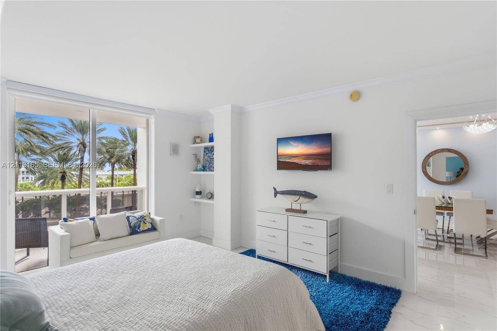 10275 Collins Avenue, #229, Bal Harbour, FL 33154 Floor-to-ceiling glass sliding doors, polished stone-finish flooring, built-in recessed shelving, and crown molding