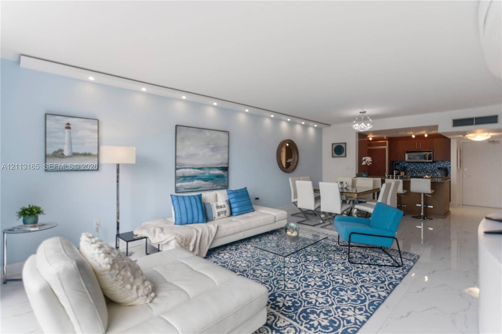 10275 Collins Avenue, #229, Bal Harbour, FL 33154 Open-concept interior featuring large-format tile flooring, recessed architectural track lighting, and a kitchen peninsula with integrated seating