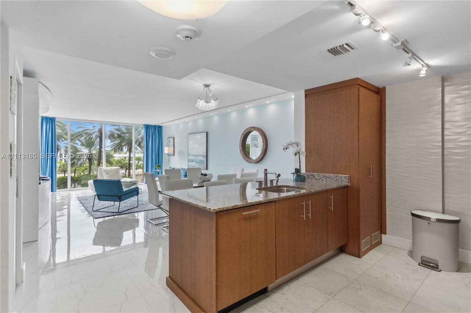10275 Collins Avenue, #229, Bal Harbour, FL 33154 Kitchen featuring wood-finish cabinetry, stone countertops, stainless steel sink, track lighting, and floor-to-ceiling windows