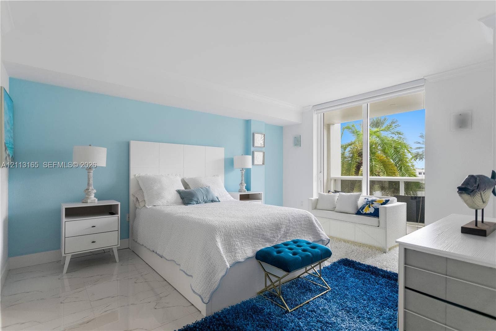 10275 Collins Avenue, #229, Bal Harbour, FL 33154 Neutral-toned interior space featuring polished stone-finish flooring, a floor-to-ceiling glass sliding door, and a built-in window bench