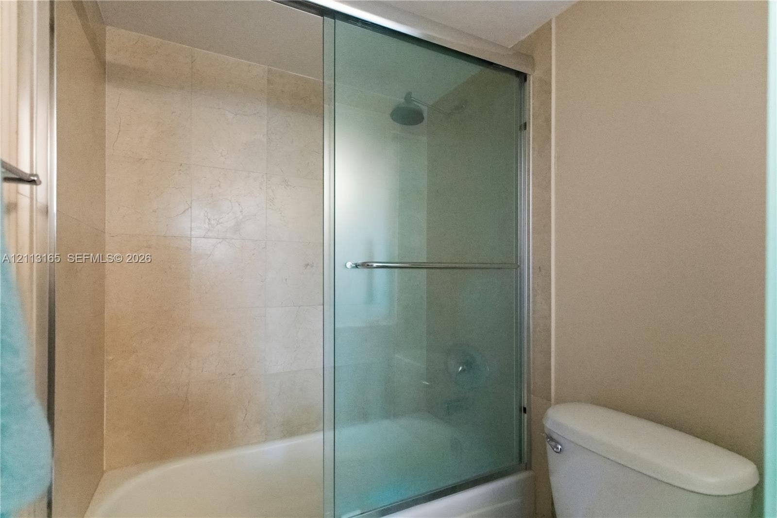 10275 Collins Avenue, #229, Bal Harbour, FL 33154 Shower-tub combination featuring floor-to-ceiling tile surround, sliding glass door, and a wall-mounted shower head