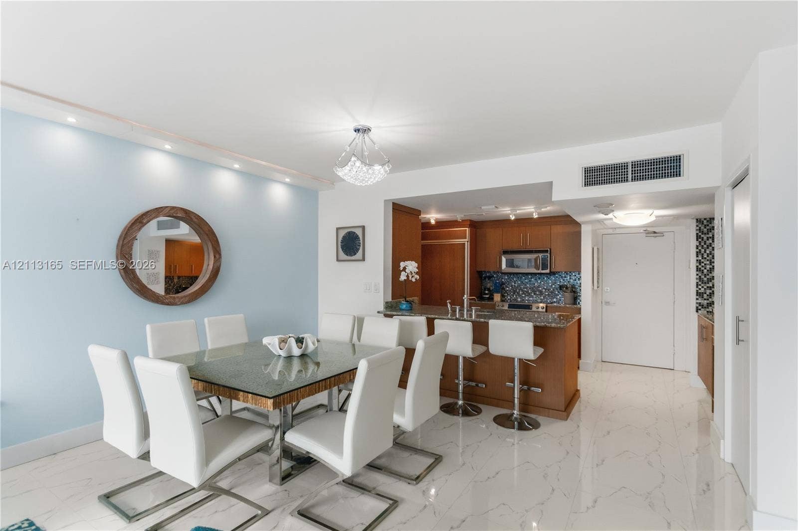 10275 Collins Avenue, #229, Bal Harbour, FL 33154 Kitchen featuring wood cabinetry, stone countertops, and integrated appliances with a breakfast bar