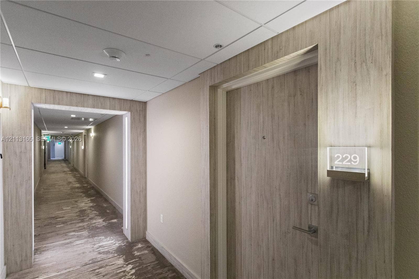 10275 Collins Avenue, #229, Bal Harbour, FL 33154 Wood-finish paneling, brushed metallic hardware, integrated door signage, and recessed ceiling lighting