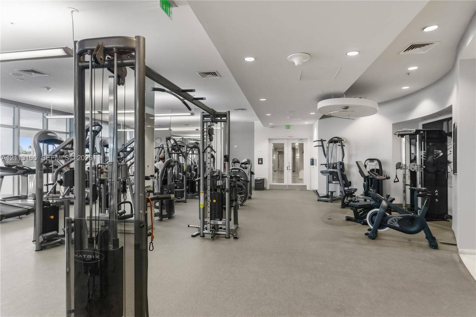 10275 Collins Avenue, #229, Bal Harbour, FL 33154 Fitness facility featuring rubberized flooring, recessed ceiling lighting, full-length mirrors, and glass double doors