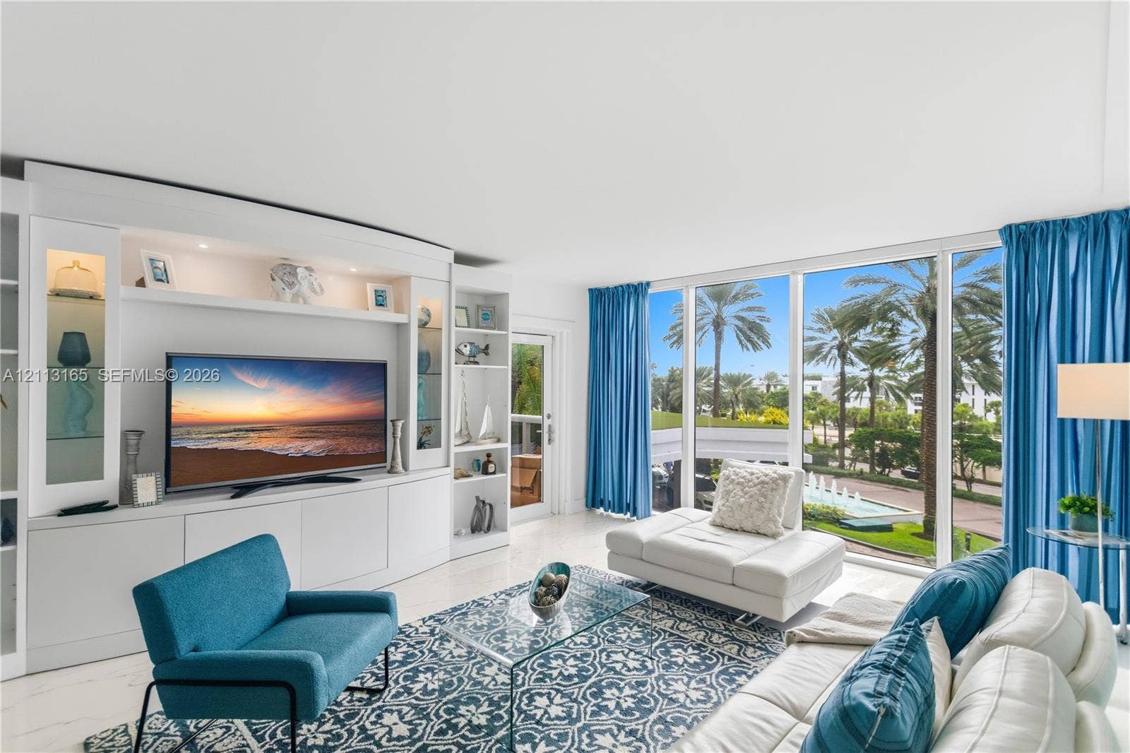 10275 Collins Avenue, #229, Bal Harbour, FL 33154 Built-in floor-to-ceiling white cabinetry with integrated display shelving and storage, expansive wall-to-wall glass windows, and polished stone-finish flooring
