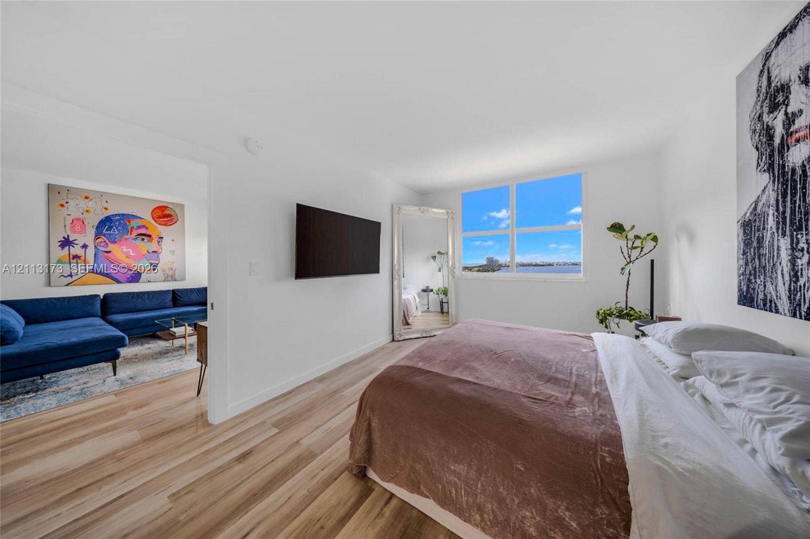 300 Bayview Drive, #1614, Sunny Isles Beach, FL 33160 Interior space featuring wood-finish flooring, large rectangular window, and wall-mounted television