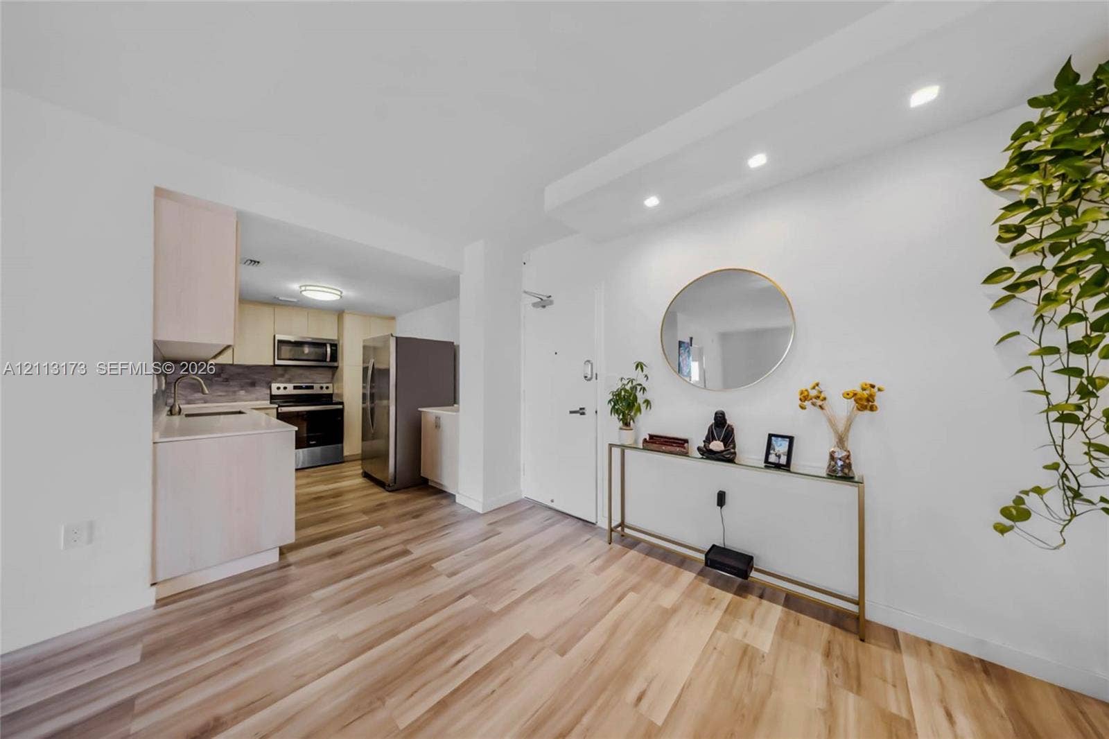 300 Bayview Drive, #1614, Sunny Isles Beach, FL 33160 Kitchen featuring light wood-finish cabinetry, stainless steel appliances, and solid surface countertops