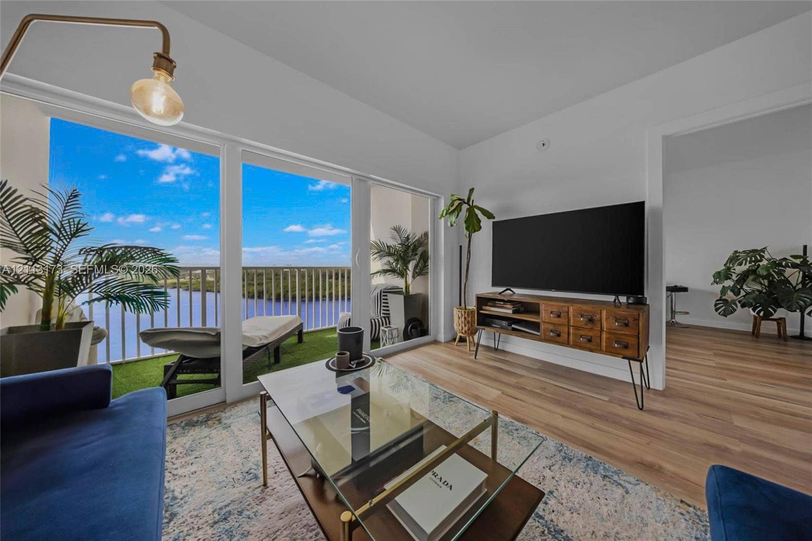 300 Bayview Drive, #1614, Sunny Isles Beach, FL 33160 Floor-to-ceiling windows, wood-finish flooring, and a private balcony with metal railing