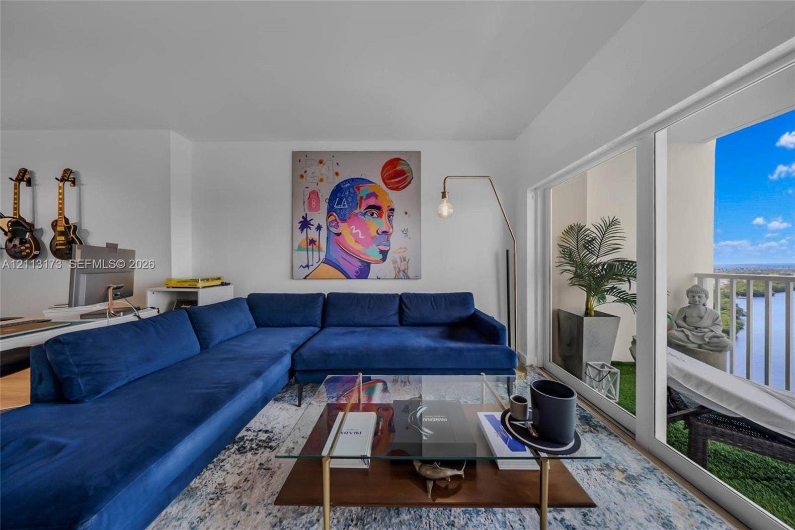 300 Bayview Drive, #1614, Sunny Isles Beach, FL 33160 Living area featuring large-format sliding glass doors, floor-to-ceiling windows, and access to a balcony with water scenery