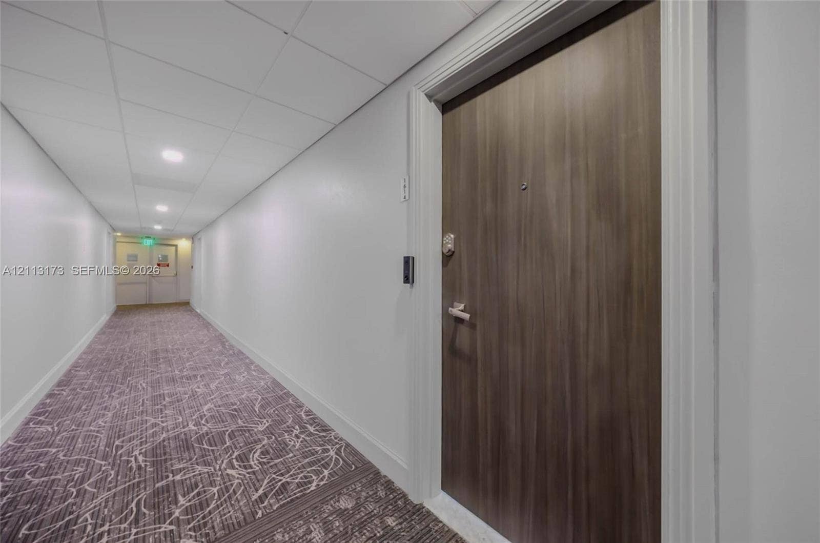 300 Bayview Drive, #1614, Sunny Isles Beach, FL 33160 Wood-finish entry door with metal hardware, recessed ceiling lighting, and patterned carpeting